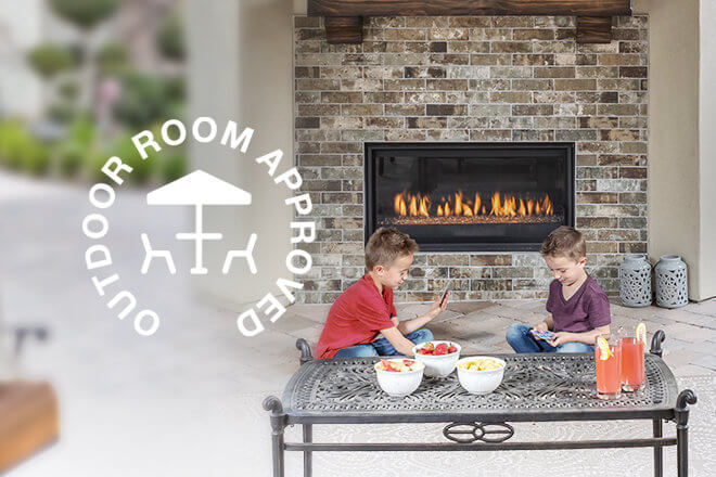 Outdoor Room Approved logo shown with children in front of a fireplace installed outdoors